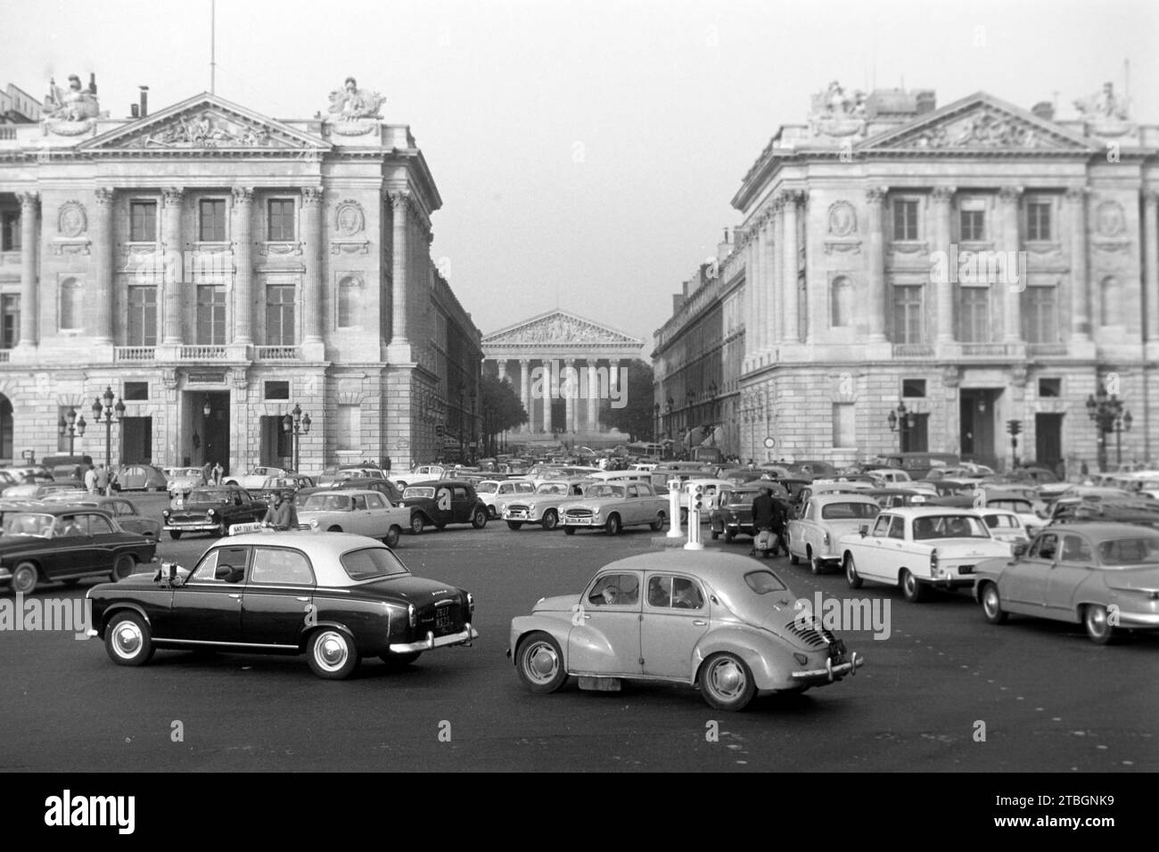 Der Straßenverkehr an der place de la Concorde, Links das Hotel de Crillon, rechts das Hotel de la Marine, in der Mitte die Madeleine, eine Pfarrkirche im klassizistischen Stil, Paris 1962. La circulation à la place de la Concorde, à gauche l'Hôtel de Crillon, à droite l'Hôtel de la Marine, au centre la Madeleine, église paroissiale de style néoclassique, Paris 1962. Banque D'Images