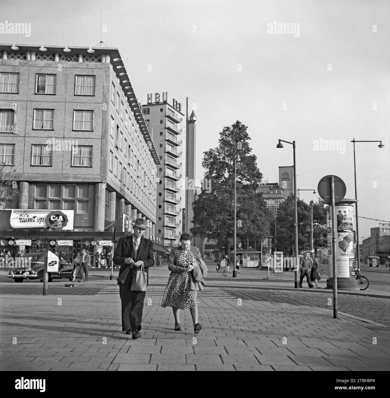 Une vue de la rue de Rotterdam en 1955 – elle a été photographiée en regardant vers le sud avec des gens marchant sur Coolsingel à l'intersection avec Beursplein. Beursplein est maintenant piétonne avec un centre commercial et une station de métro sous le niveau du sol. Un grand magasin de vêtements C&A est au coin de la rue (aujourd'hui grandement modernisé) - une photographie vintage des années 1950. Banque D'Images