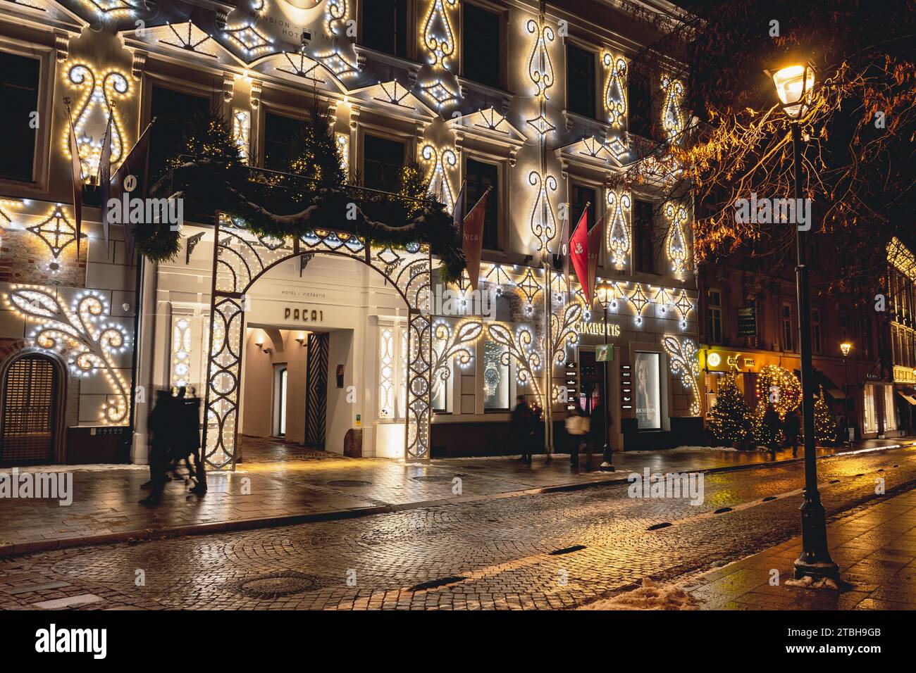 Belle entrée et fenêtres d'un hôtel avec décorations de Noël confortables, couronne, guirlandes et lumières dans la vieille ville de Vilnius, capitale de la Lituanie Banque D'Images