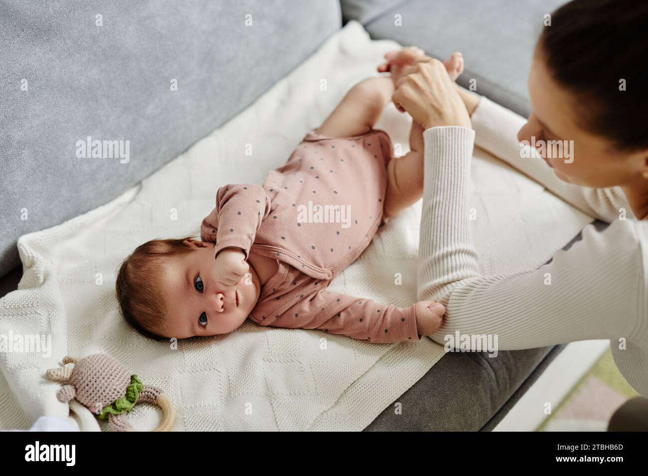 Mère massant les pieds de bébé couché sur la table Banque D'Images