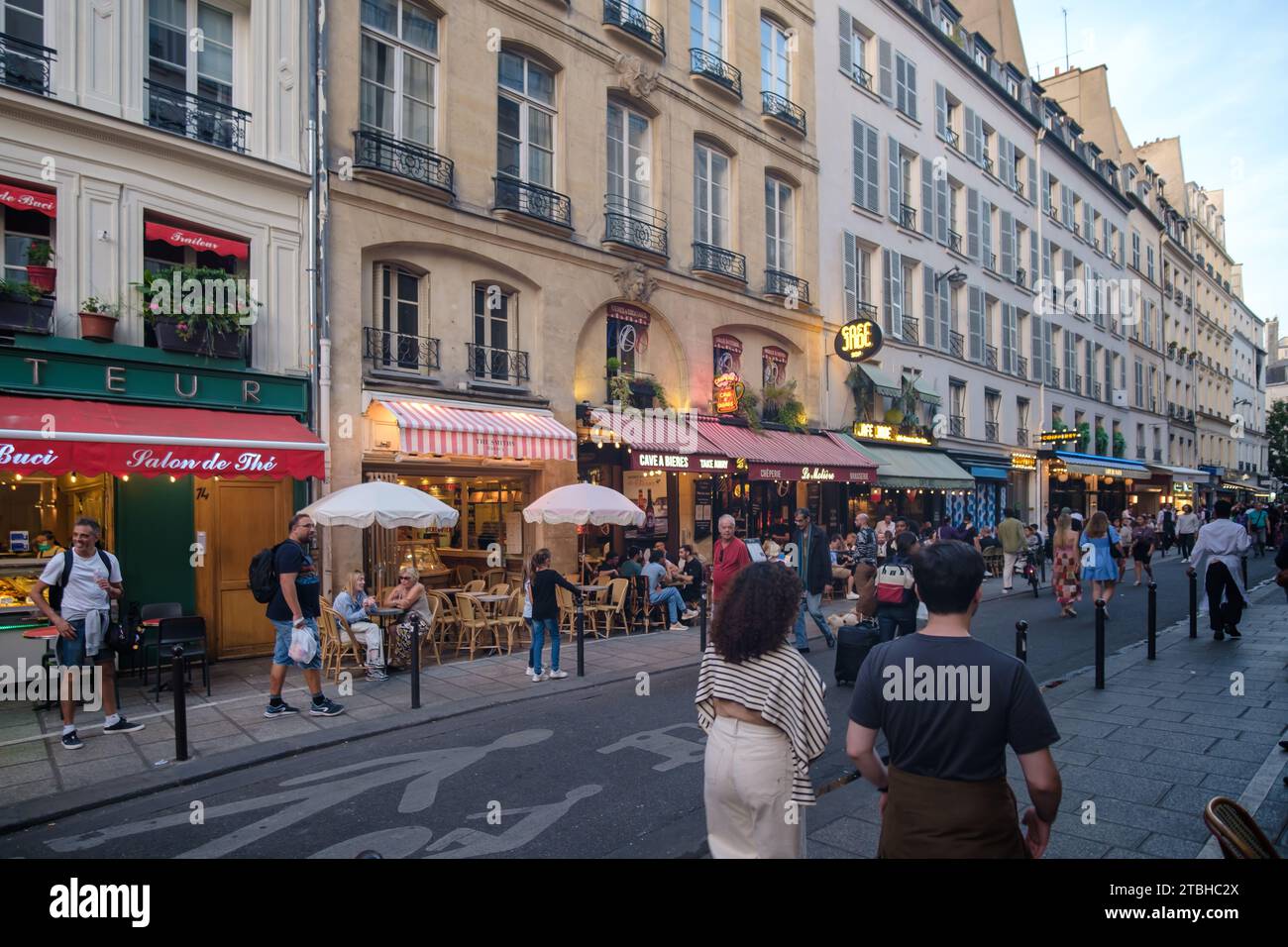 Paris, France - 8 octobre 2023 : les touristes et les Parisiens dégustent des plats et des boissons en plein air dans la célèbre rue de Buci à Saint Germain Paris France Banque D'Images