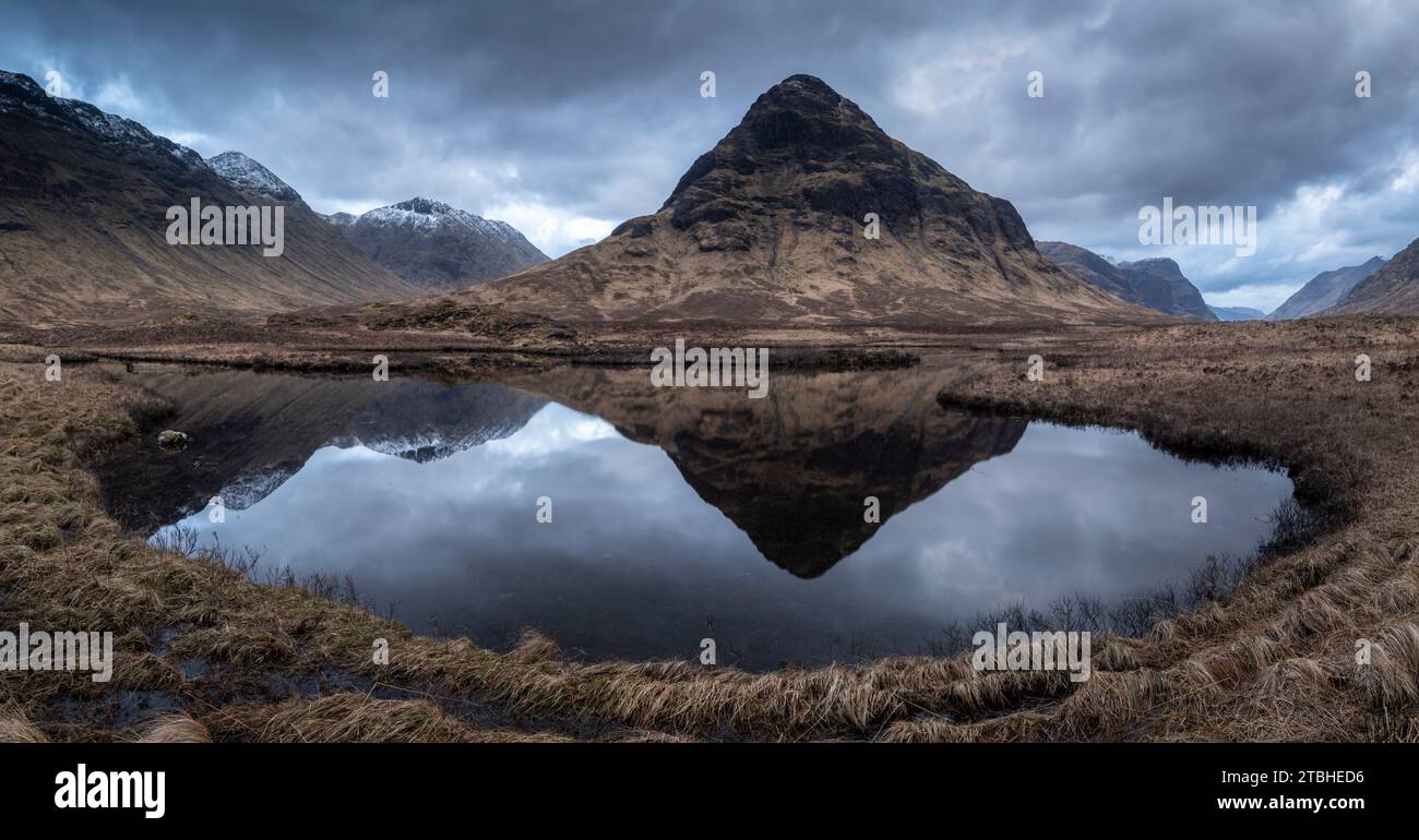 Buachaille Etive Beag montagne reflétée dans les eaux calmes de Lochan na Fola, Glencoe, Highland, Écosse. Printemps (mars) 2023. Banque D'Images