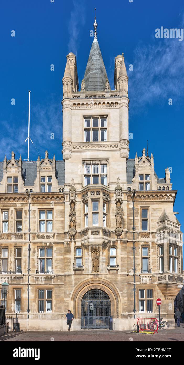 Un étudiant se loge contre un mur du Gonville & Caius College, Université de Cambridge, Angleterre, par une journée ensoleillée. Banque D'Images