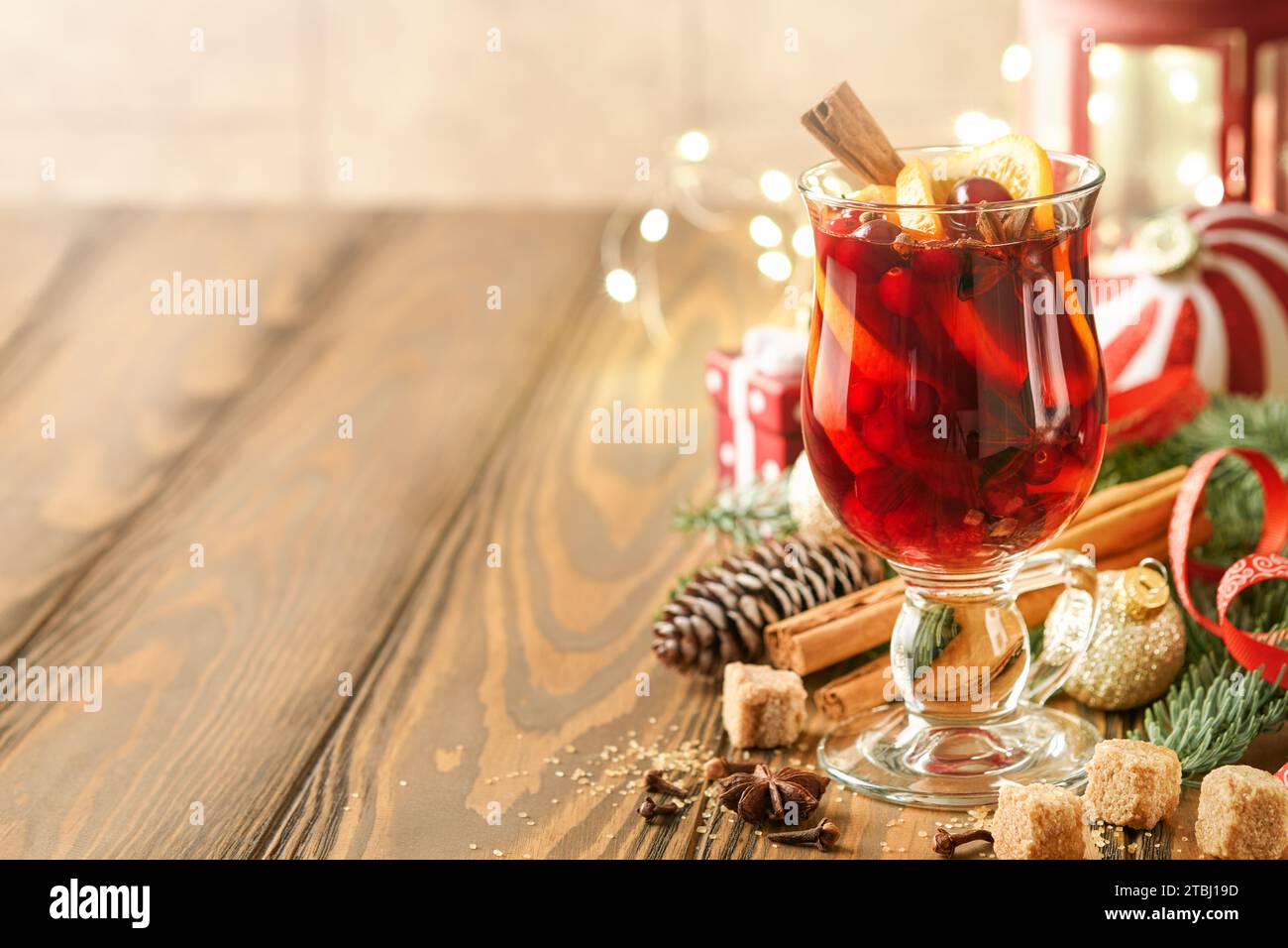 Noël boit du vin chaud chaud. Verre de vin chaud aux épices aromatiques cannelle, anis, sucre et branches de sapin avec bokeh et décorations. T Banque D'Images