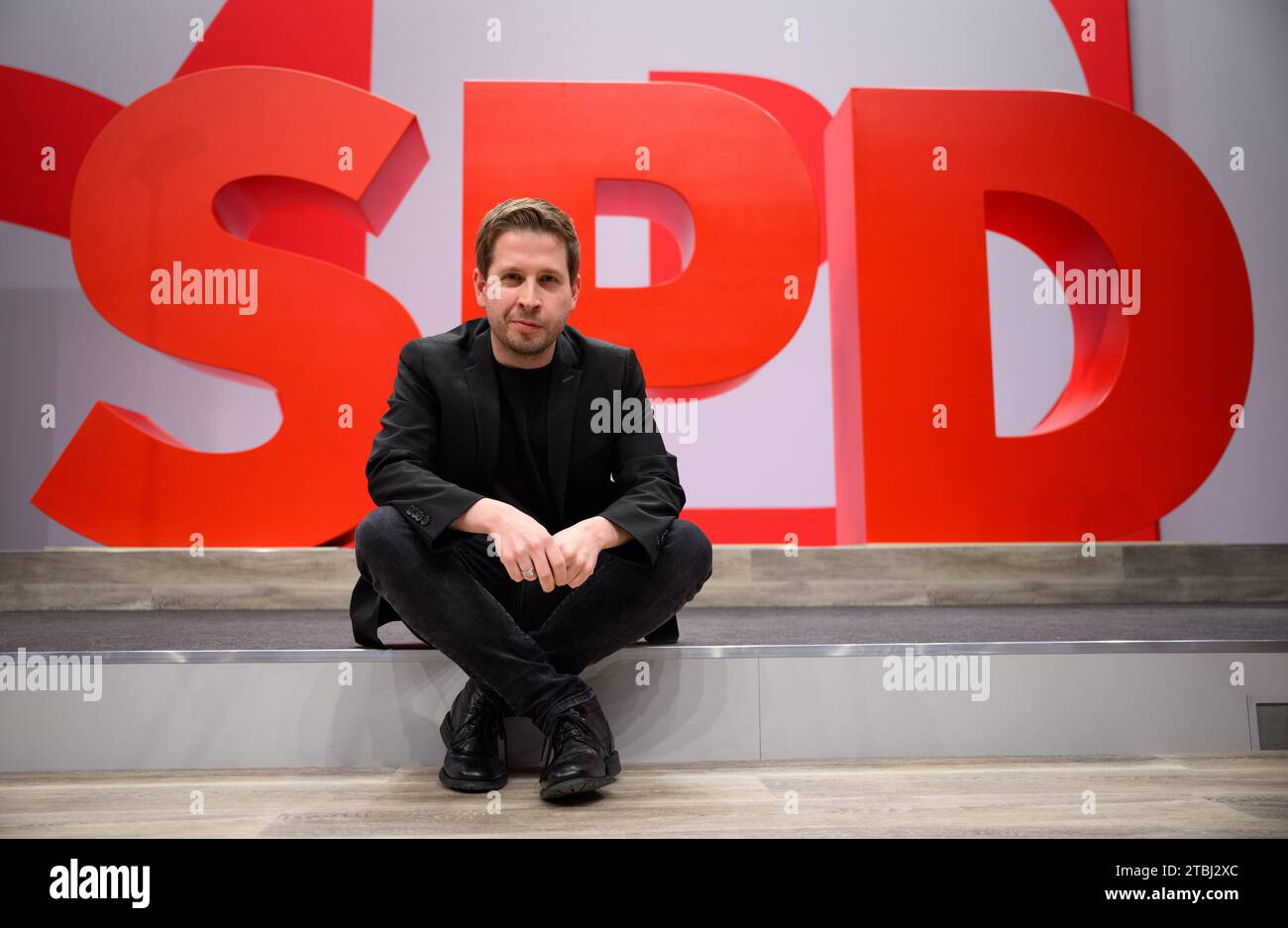 Berlin, Allemagne. 07 décembre 2023. Kevin Kühnert, secrétaire général du SPD, est assis devant un logo du SPD lors d'une visite du lieu de la conférence à l'approche de la conférence nationale régulière du SPD. La conférence nationale régulière du parti SPD aura lieu sur le terrain d'exposition de Berlin du 8 au 10 décembre 2023. Entre autres, la conférence du parti élira un nouveau comité exécutif du SPD et fixera le cap programmatique pour les années à venir. Crédit : Bernd von Jutrczenka/dpa/Alamy Live News Banque D'Images