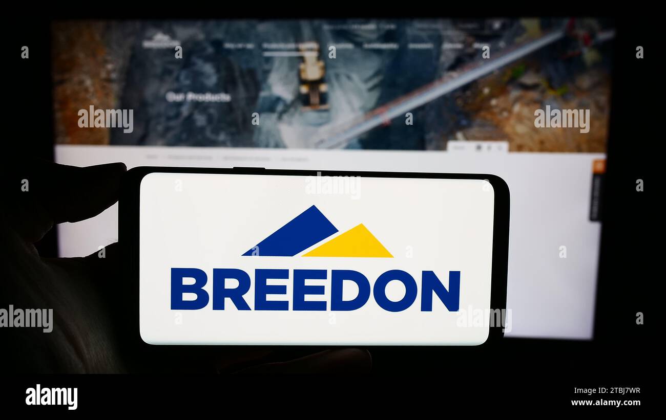 Personne tenant un téléphone portable avec le logo de la société britannique de matériaux de construction Breedon Group plc devant la page Web. Concentrez-vous sur l'affichage du téléphone. Banque D'Images