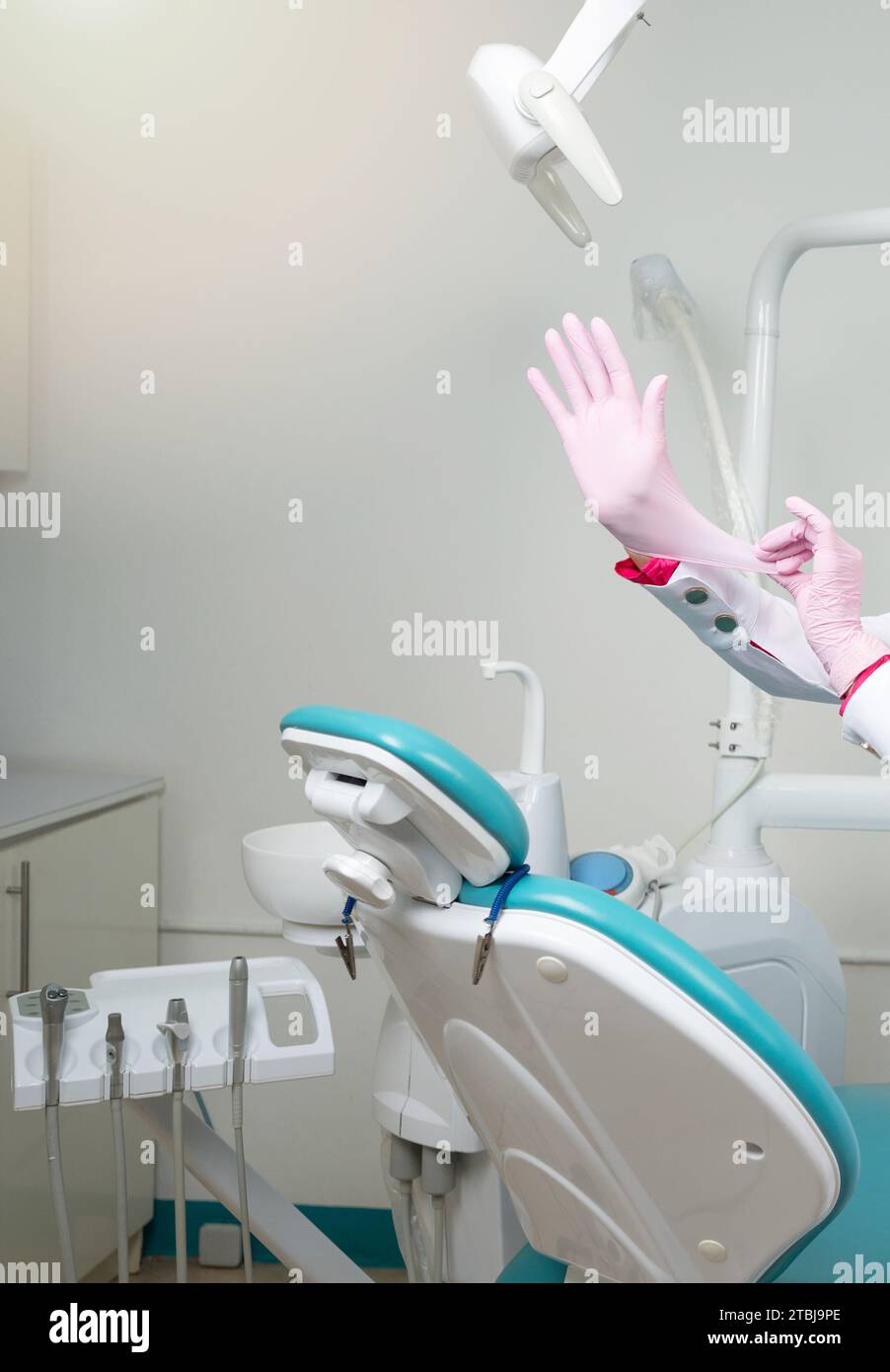 Dentiste a mis des gants propres sur le fond de chaise de cabinet de chambre Banque D'Images