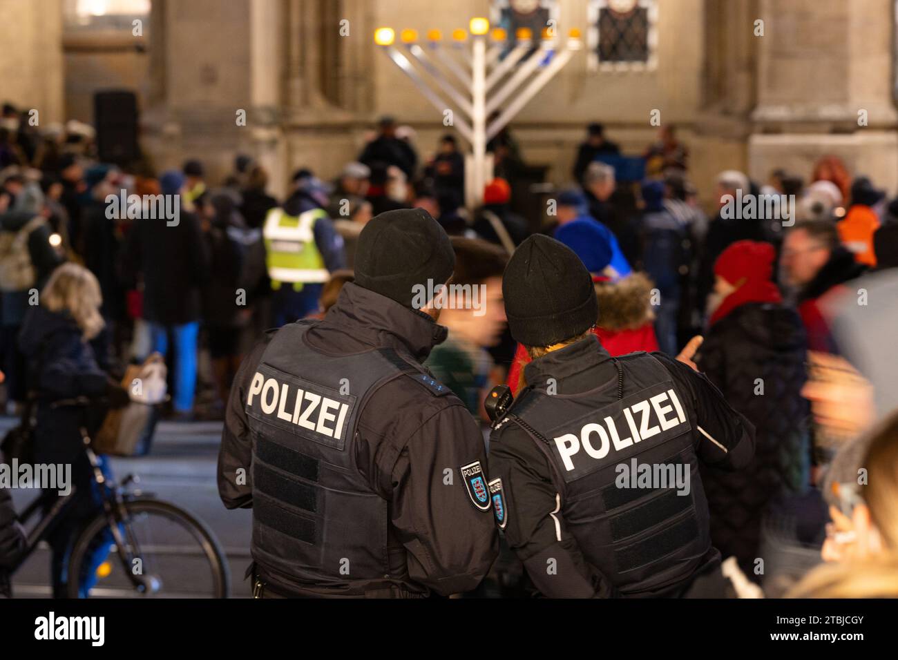 Erfurt, Allemagne. 07 décembre 2023. Des policiers gardent les célébrations pour l'allumage de la première lumière sur le candélabre Hanoukka devant la mairie. La fête des lumières est célébrée pour commémorer la redédicace du deuxième temple juif de Jérusalem en 165 av. J.-C. et se termine le 15 décembre. Crédit : Michael Reichel/dpa/Alamy Live News Banque D'Images