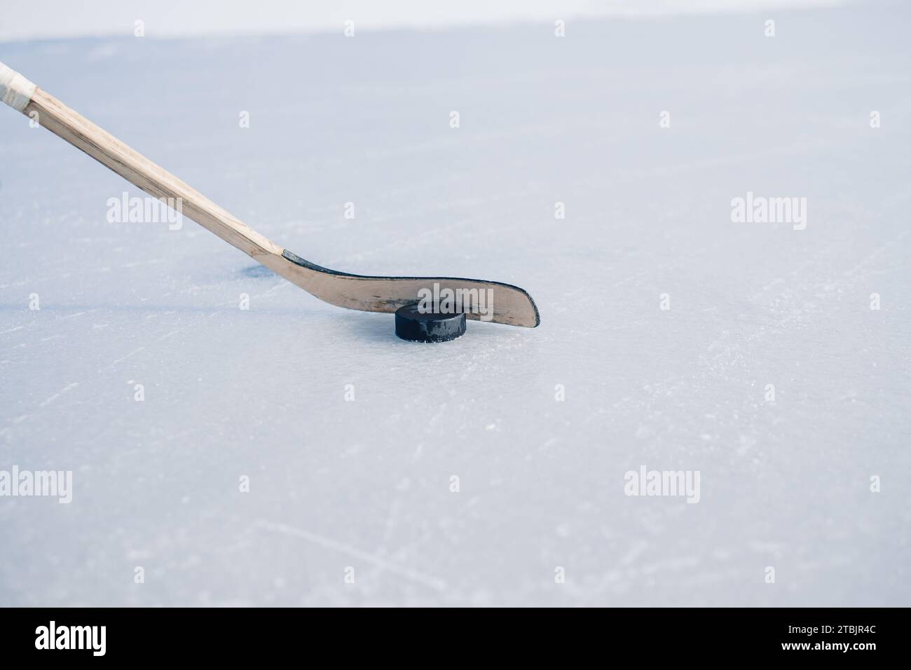 Gros plan, crosse de hockey et palet sur glace. Banque D'Images