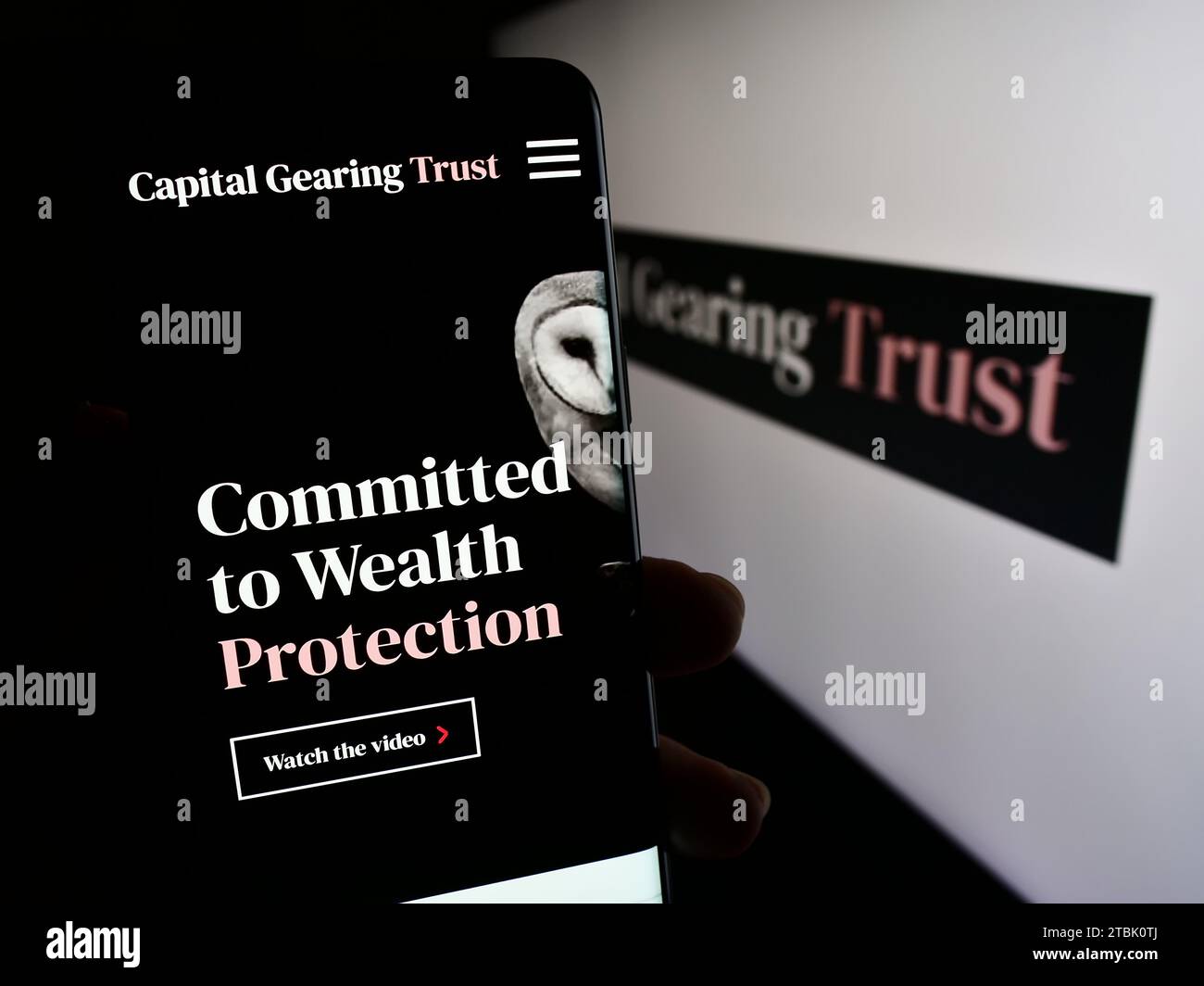 Personne détenant un téléphone portable avec page Web de la société d'investissement britannique Capital Gearing Trust plc (CGT) avec logo. Concentrez-vous sur le centre de l'écran du téléphone. Banque D'Images