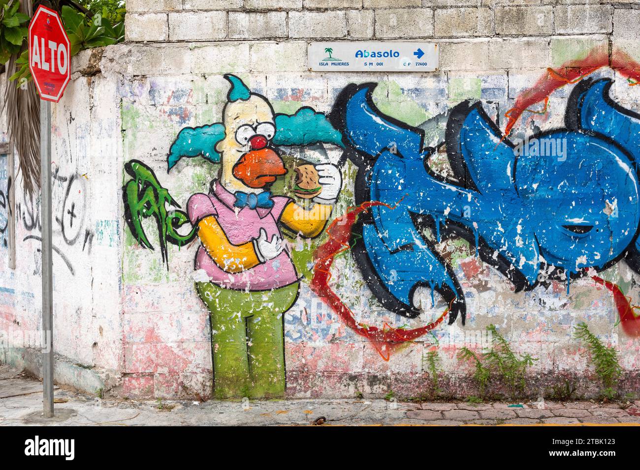 Mexique, Isla Mujures, mur mural grafitti de croustillant le Clown ayant un hamburger Banque D'Images