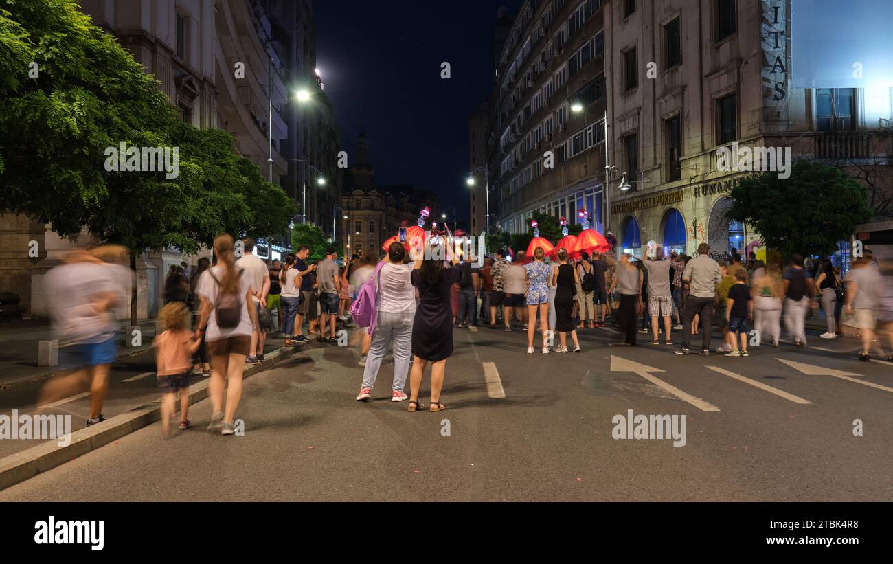 Foule de gens marchant sur la voiture piétonne seulement rue, la nuit. Bucarest, Roumanie - 1 juillet 2023. Banque D'Images