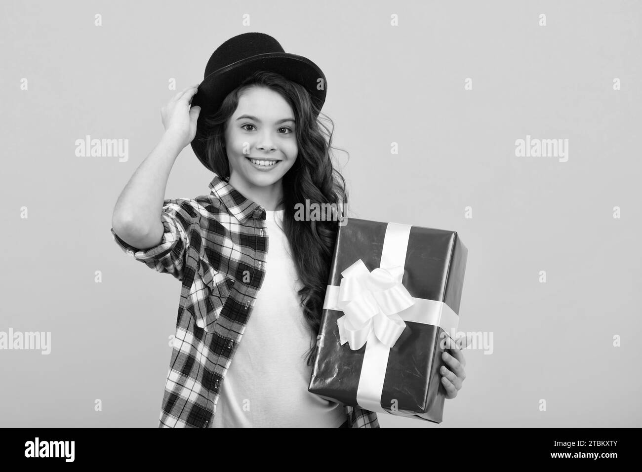 Enfant avec boîte cadeau sur fond isolé. Cadeaux pour l'anniversaire, le jour de la Saint-Valentin, le nouvel an ou Noël. Adolescent heureux, positif et souriant Banque D'Images