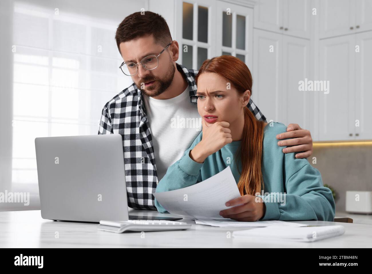 Couple utilisant un ordinateur portable pour payer des impôts à la maison Banque D'Images