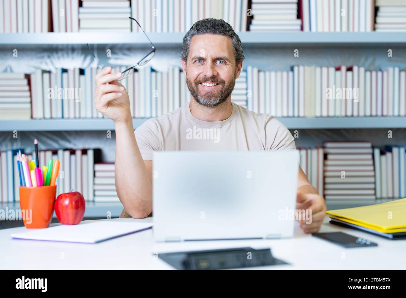 Professeur tuteur avec ordinateur portable dans la salle de classe de l'école. Connaissance, éducation. Homme avec leçon d'enseignement de livre en classe. Examen universitaire. Étudier enseigner à l'université Banque D'Images