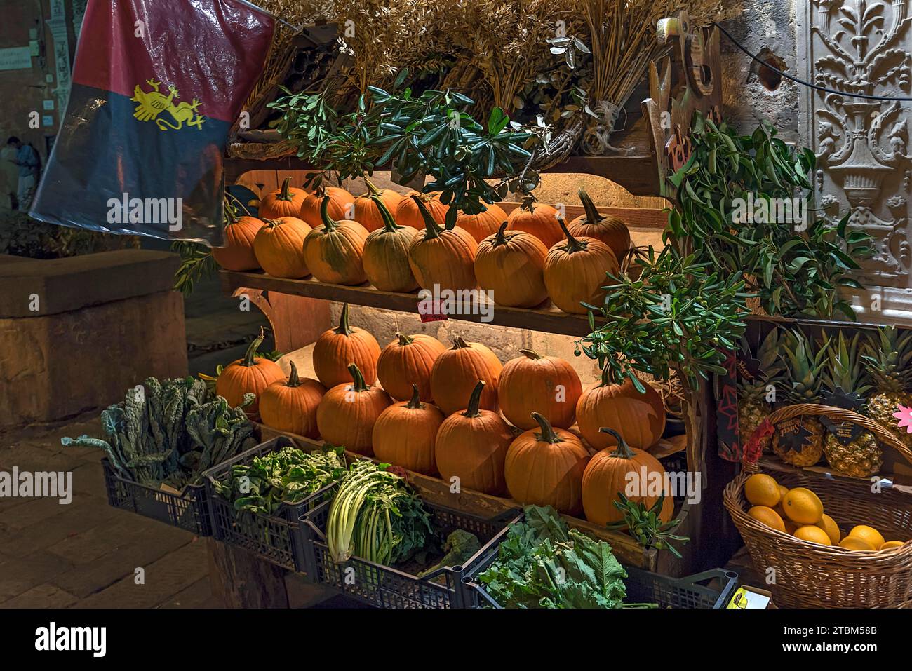 Étagères de citrouilles Hokkaido devant un magasin de fruits ouvert la nuit dans le centre historique de Gênes, Italie Banque D'Images