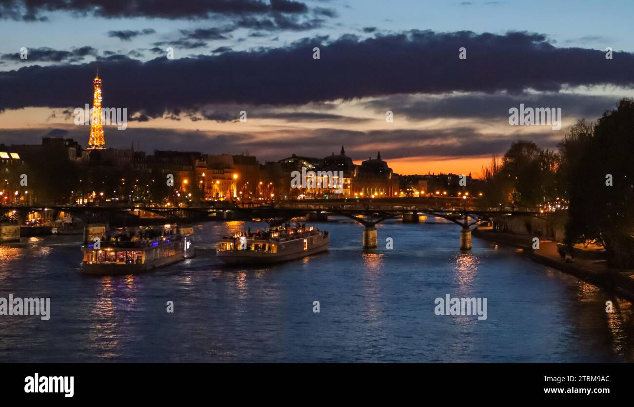 Belle nuit, Paris, Tour Eiffel étincelante, bridge pont des arts sur la Seine et les bateaux touristiques. France Banque D'Images