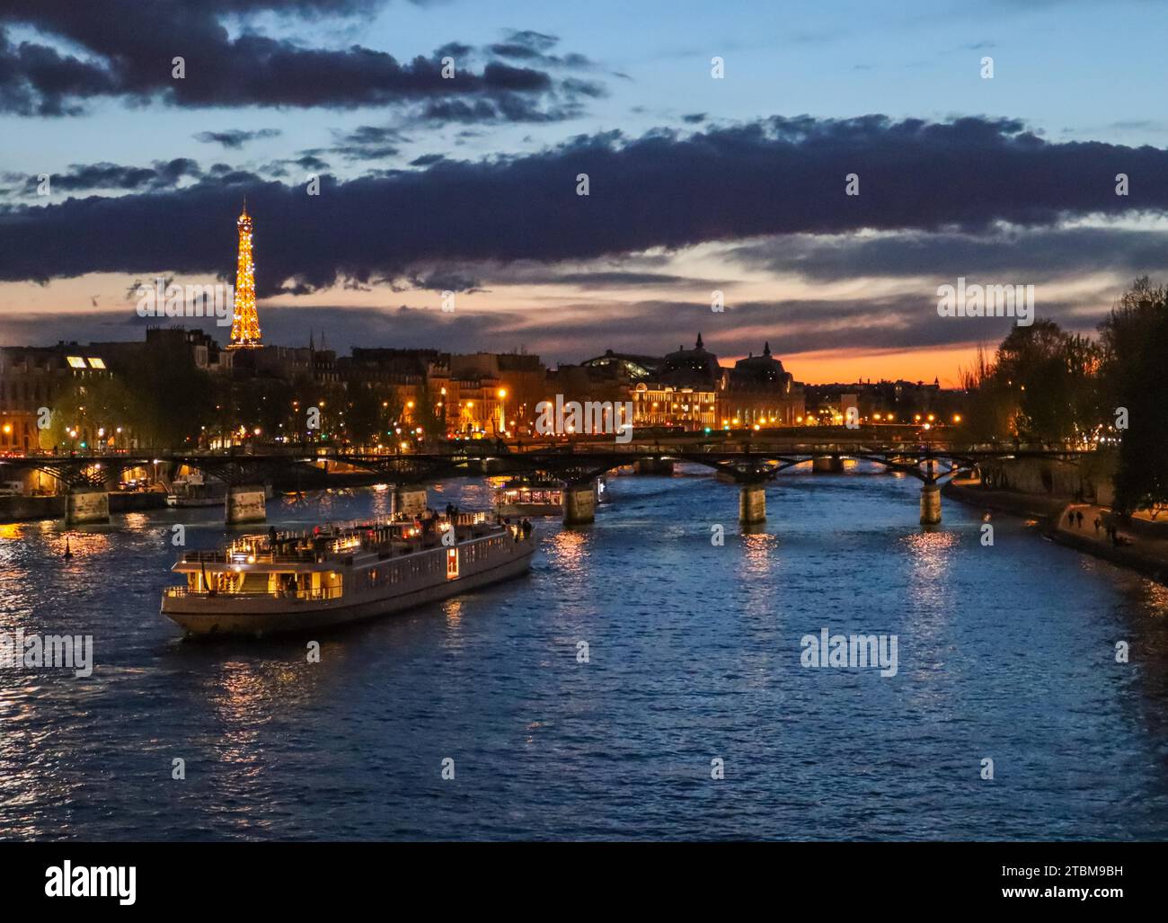 France, avril 03 2019. Belle nuit Paris, tour Eiffel étincelante, pont Pont des Arts sur la Seine et bateaux touristiques Banque D'Images