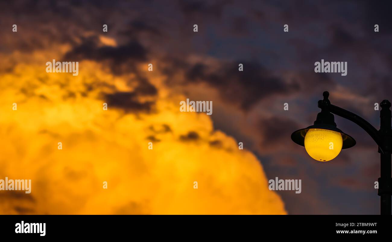 Arrière-plan d'un coucher de soleil coloré lumineux avec des nuages orange et une lampe de rue jaune.Photo de haute qualité Banque D'Images Arrière-plan d'un coucher de soleil coloré lumineux avec des nuages orange et une lampe de rue jaune.Photo de haute qualité Banque D'Images