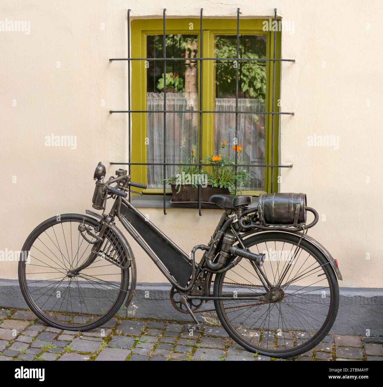 Un vieux vélo antique avec réservoir de carburant en forme de baril de vin attaché à la crémaillère arrière. Vélo vintage en métal à moteur à essence. Gros plan. Détails Banque D'Images