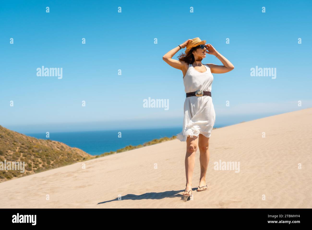 Femme debout sur un point de vue de la mer côtière dans une journée venteuse à Cabo de Gata, Espagne Banque D'Images