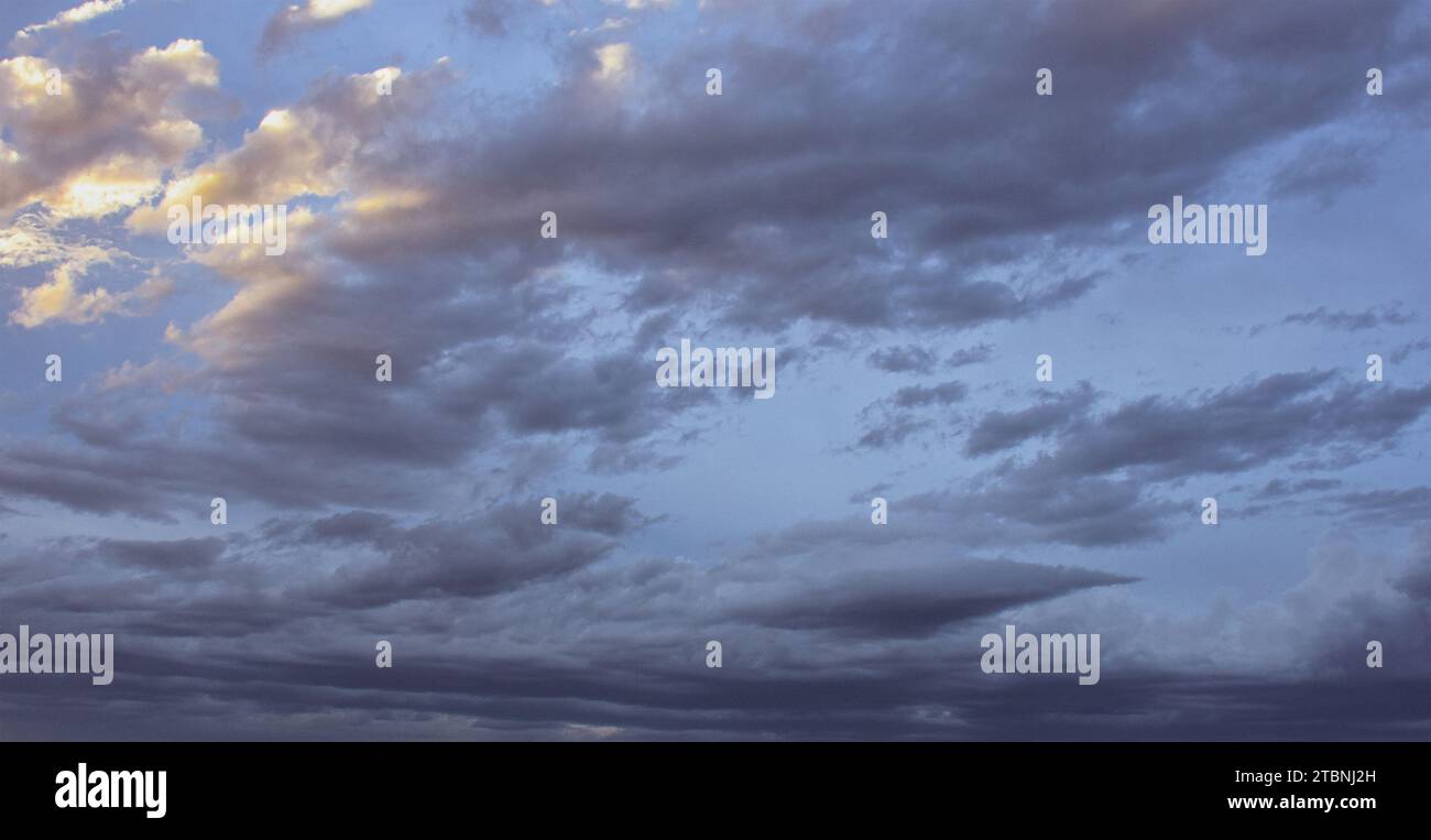 Ciel nuageux avec des nuages gris et dorés Banque D'Images