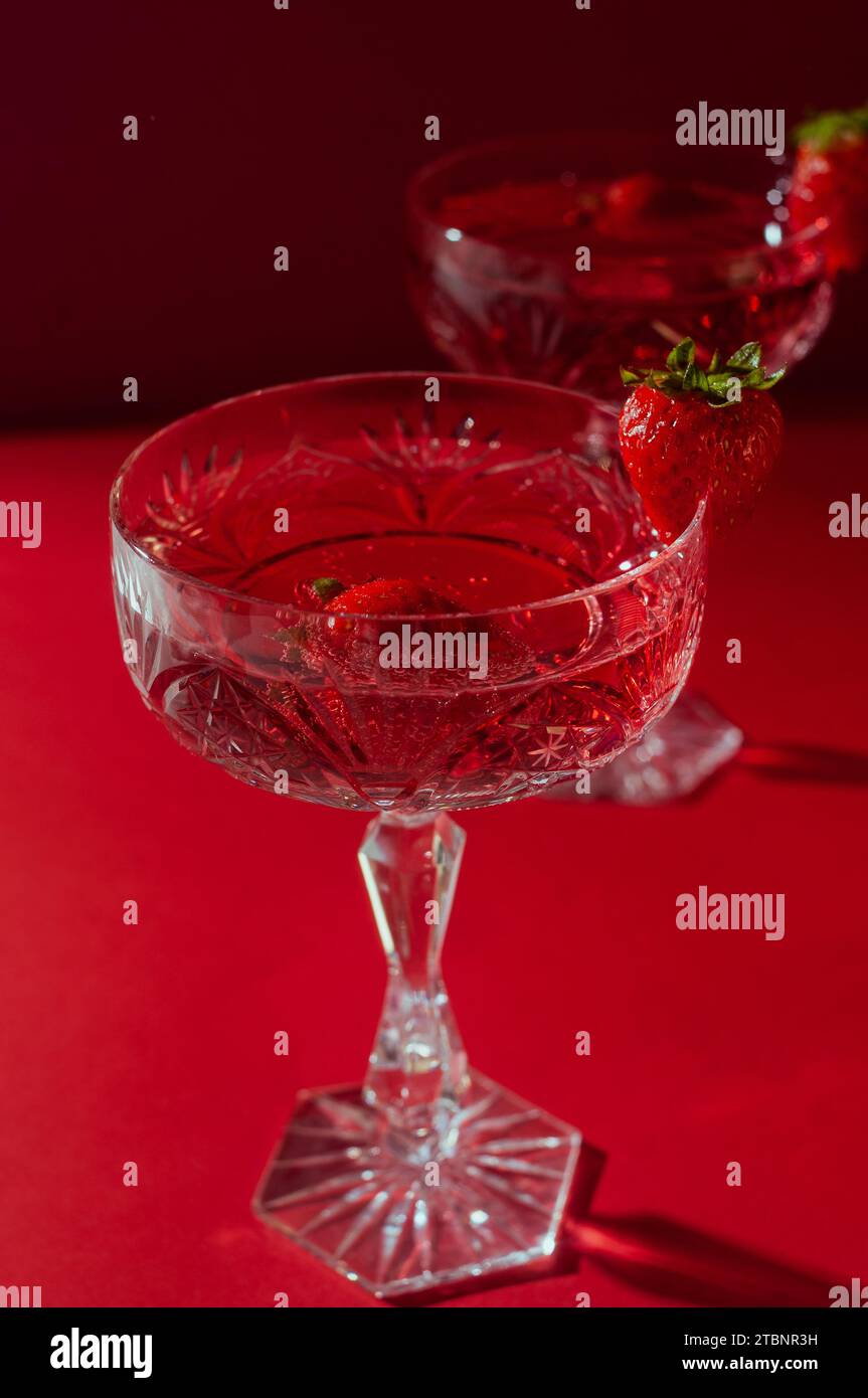 Deux verres de vin mousseux rose sur fond rouge concept romantique de Saint Valentin Banque D'Images