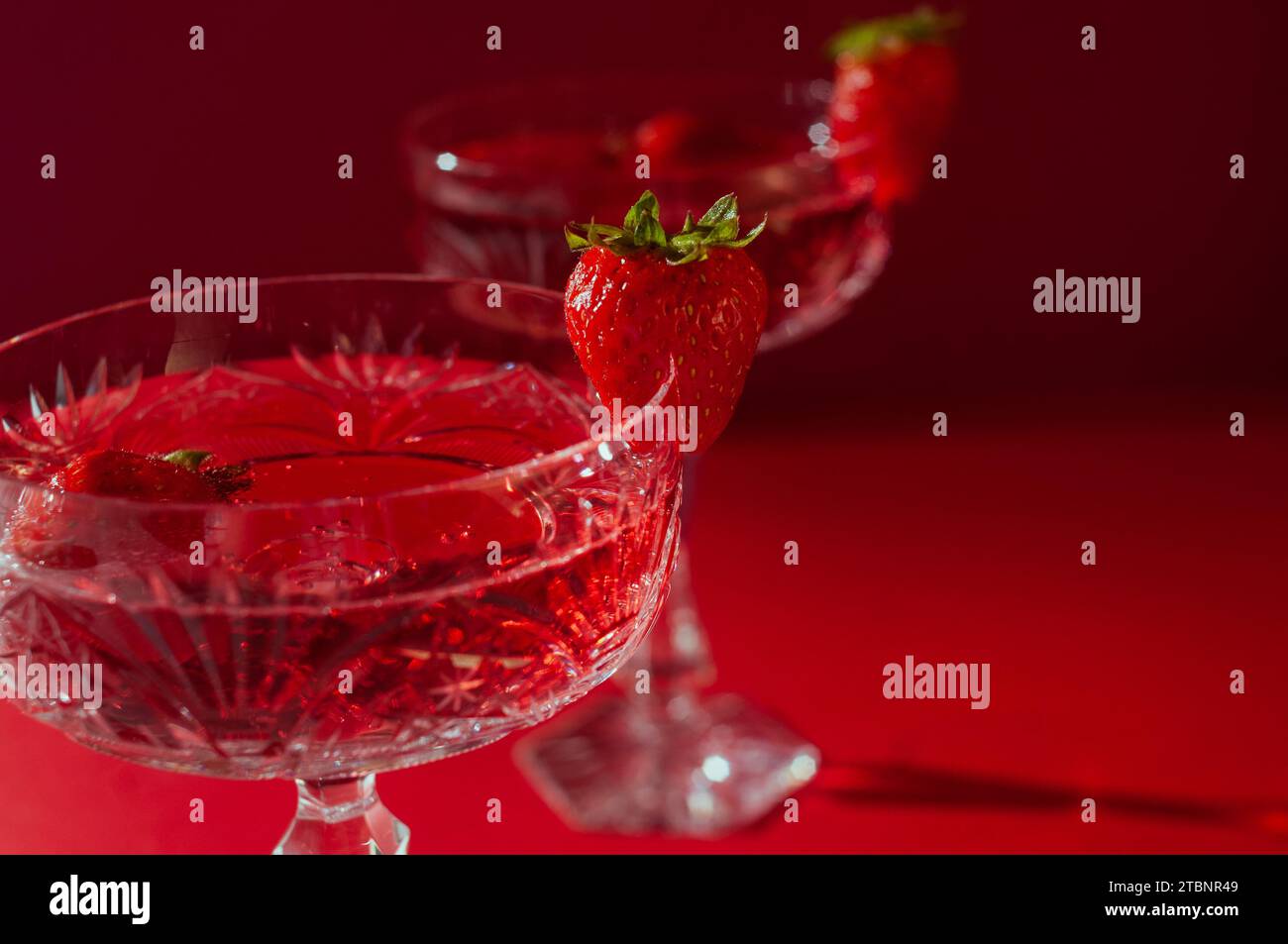 Deux verres de vin mousseux rose sur fond rouge concept romantique de Saint Valentin Banque D'Images