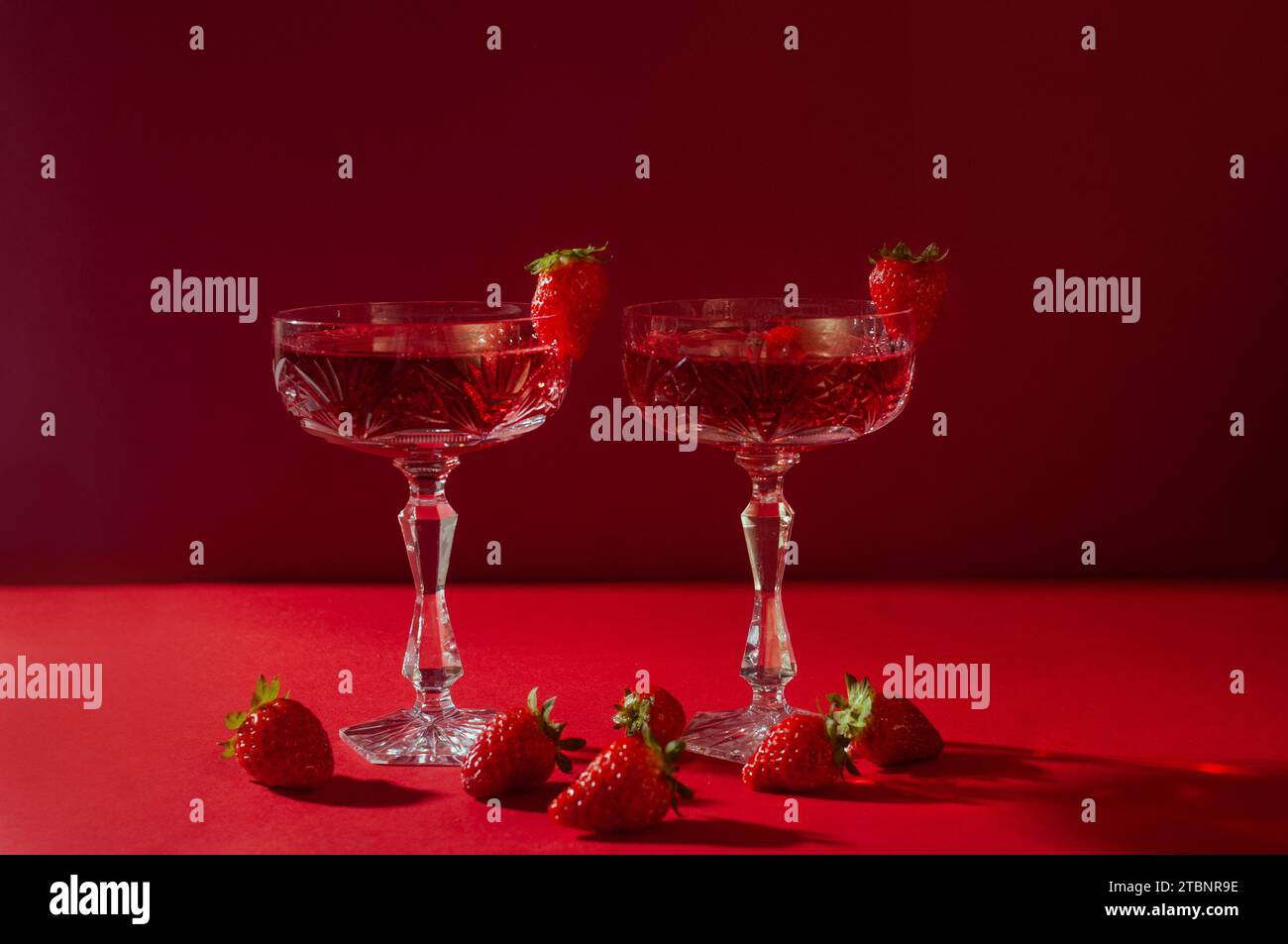 Deux verres de vin mousseux rose sur fond rouge concept romantique de Saint Valentin Banque D'Images