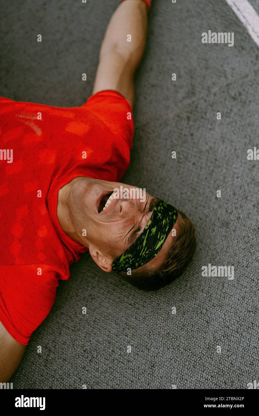 Un homme est allongé sur le sol après une compétition CrossFit. Banque D'Images