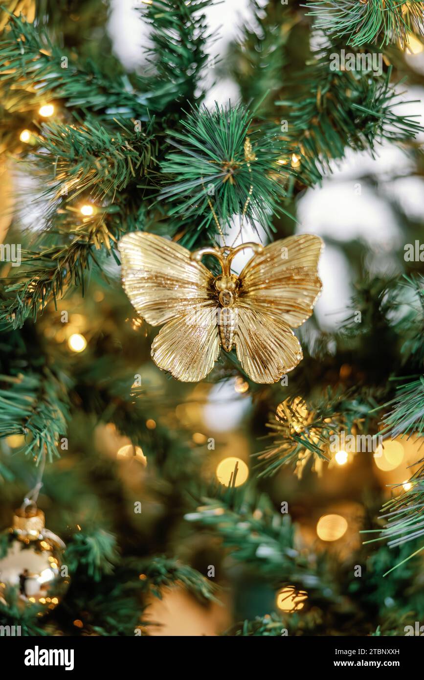 Vue rapprochée de l'ornement papillon doré sur le sapin de Noël éclairé Banque D'Images