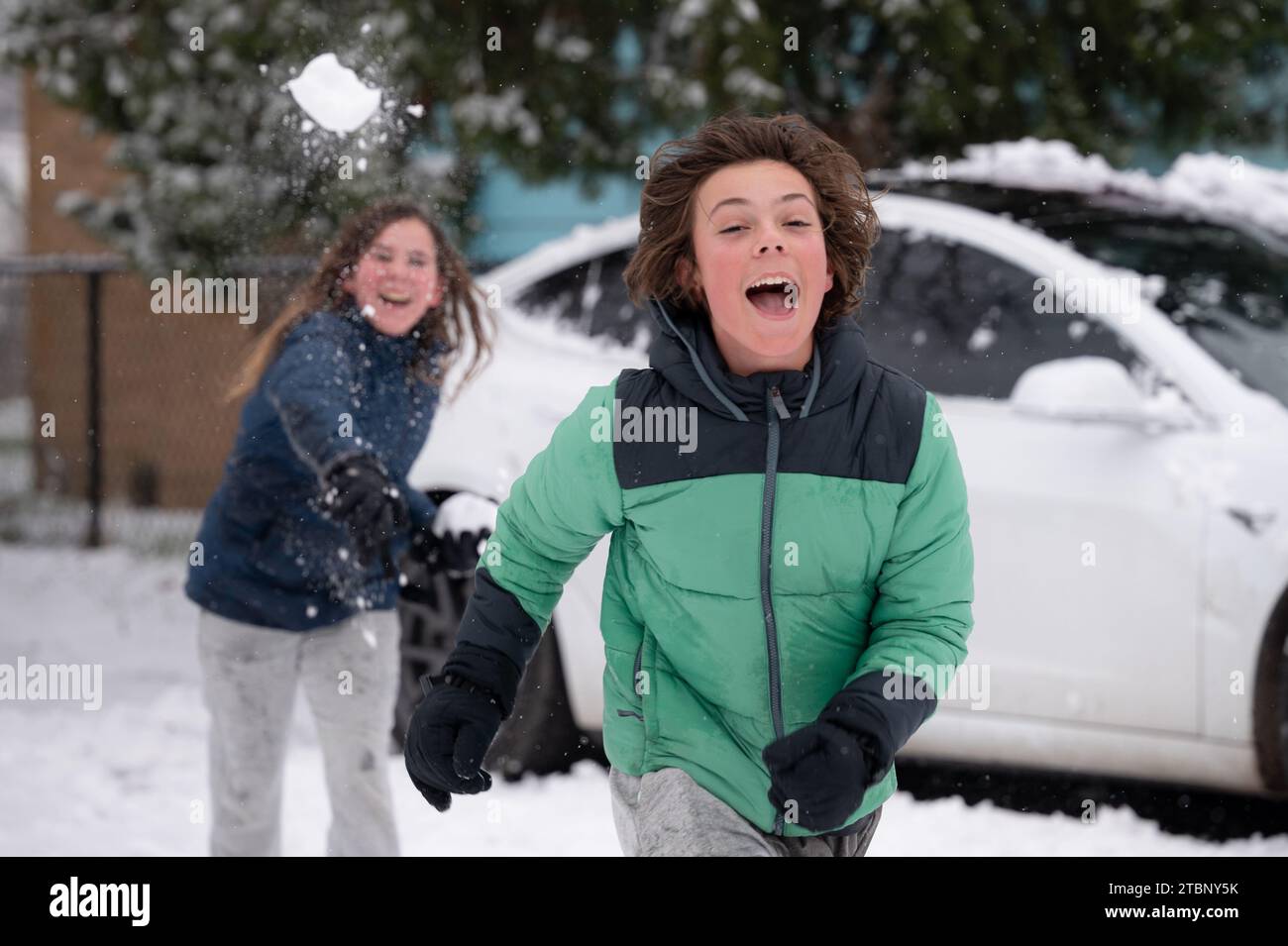 Joyeux frères adolescents ayant un combat de boules de neige en hiver Banque D'Images