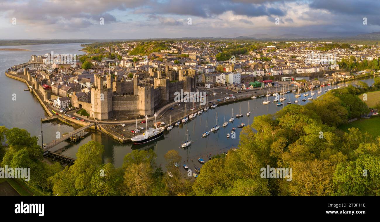 Vue aérienne du château de Caernarfon et de la ville dans la magnifique lumière du soleil du soir, Caernarfon, pays de Galles, Royaume-Uni. Printemps (mai) 2023. Banque D'Images