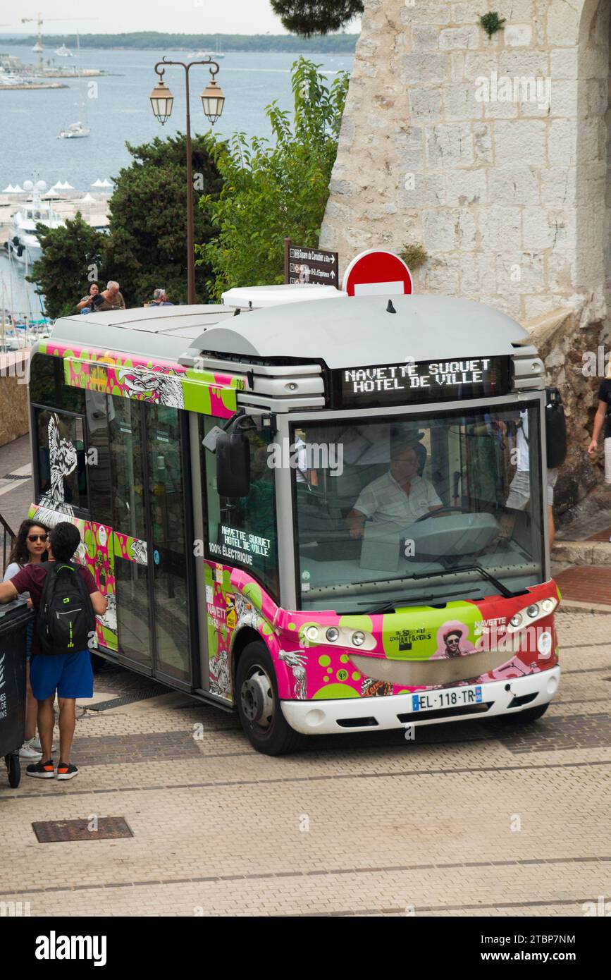 Navette saisonnière gratuite en été petit bus municipal amenant les passagers et les visiteurs à travers la cour de l'église perchée sur la colline Eglise notre-Dame d'espérance Cannes France (135) Banque D'Images