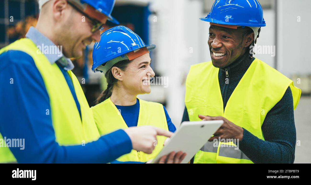 Ingénieurs travaillant à un nouveau prototype d'IA à l'intérieur de l'usine robotique - futur, travail et concept technologique - objectif principal sur le visage de la femme centrale Banque D'Images
