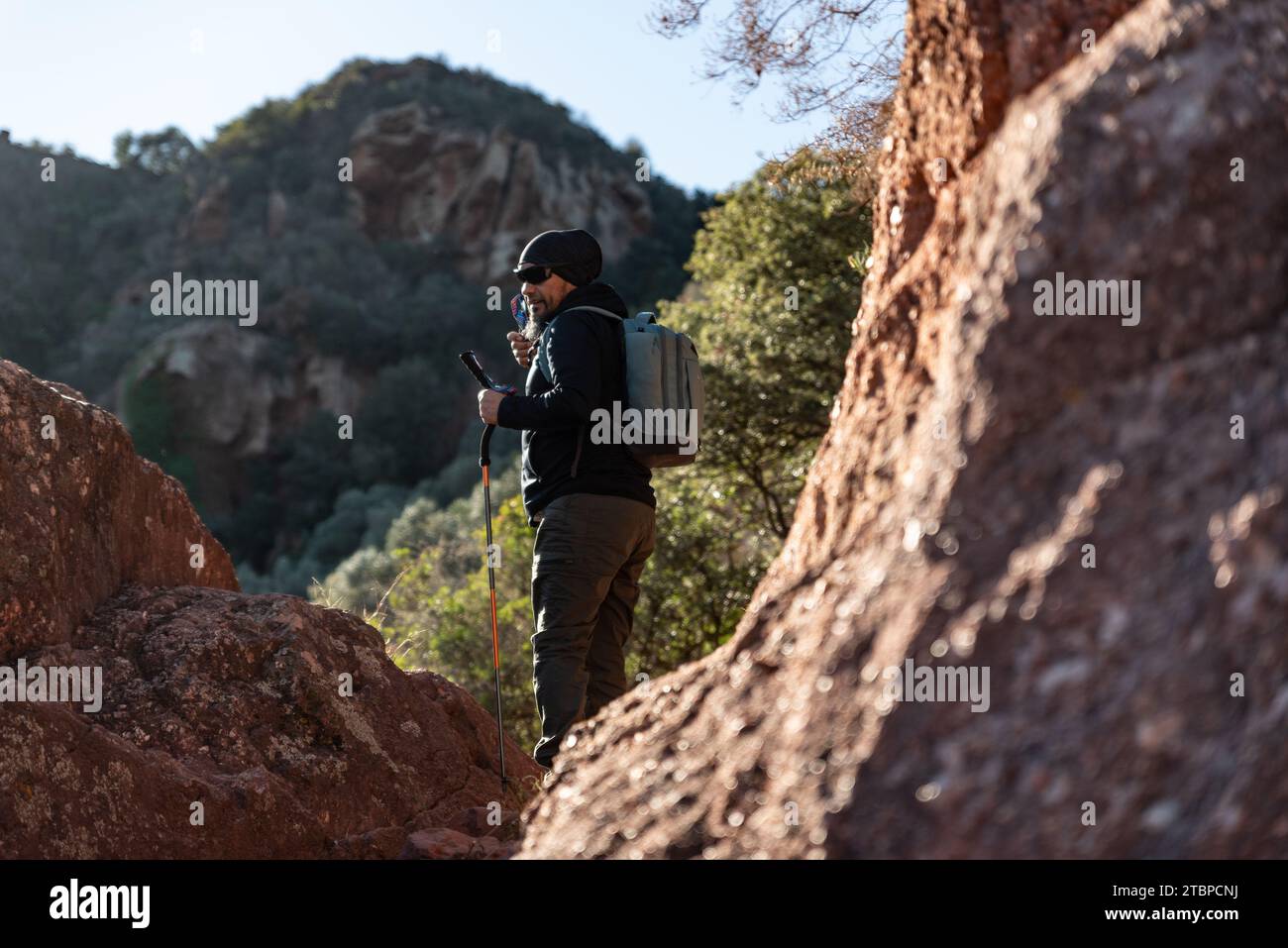 Un homme d'âge moyen contemple les paysages du parc naturel du Garraf tout en marchant le long des sentiers d'une montagne. Banque D'Images