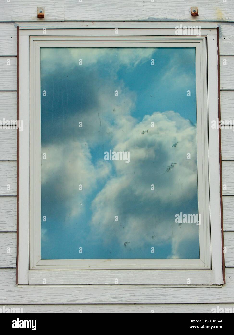 Un mur blanc avec une fenêtre ouverte avec une vue pittoresque du ciel visible dans le réflectionk Banque D'Images