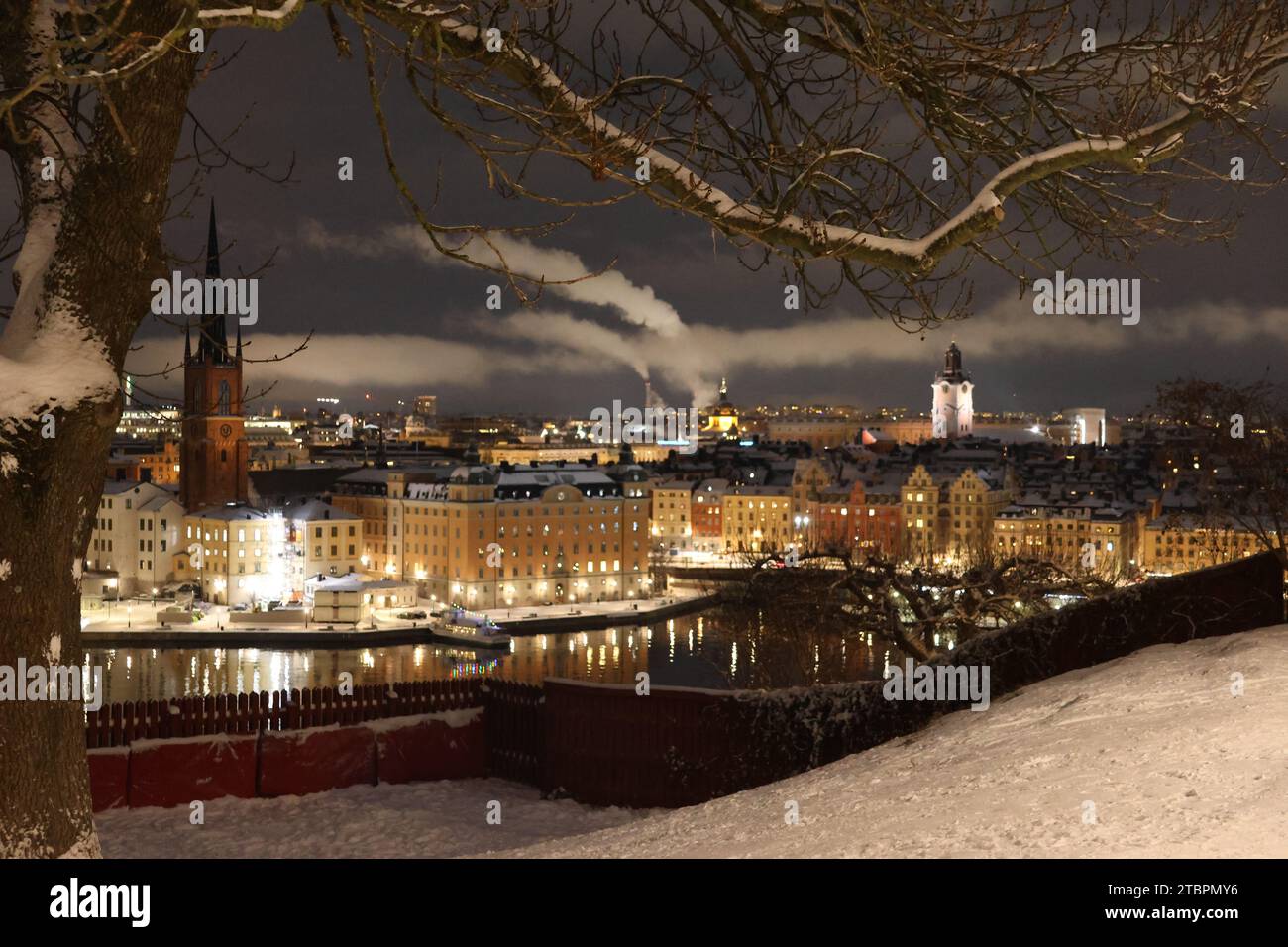 Vue imprenable ciel clair, pas de gens, eau, reflets, vieille maison, arbre, neige sur le sol. Église à gauche est le plus ancien bâtiment en Suède GoranOfSweden Banque D'Images