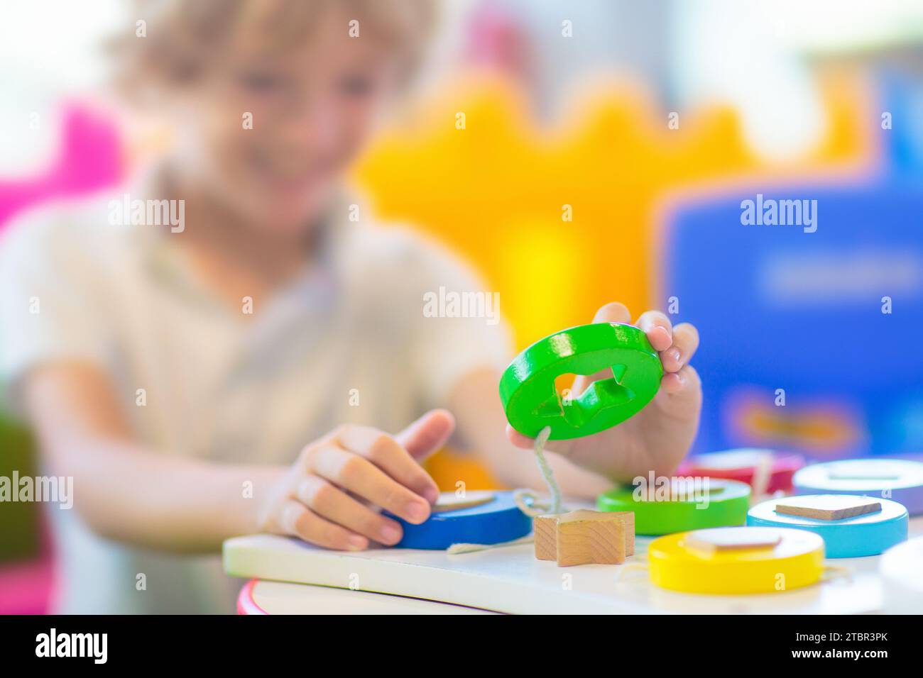 Petit garçon à la maternelle ou à la garderie. Enfant jouant avec des jouets éducatifs colorés dans la maternelle. Les enfants jouent dans l'aire de jeux intérieure. Éducation préscolaire Banque D'Images