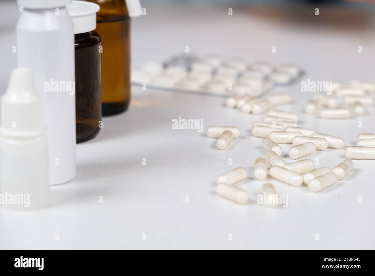 Beaucoup de capsules blanches sont dispersées sur la table. Concept de médicament, pharmacie. Placer pour le texte Banque D'Images