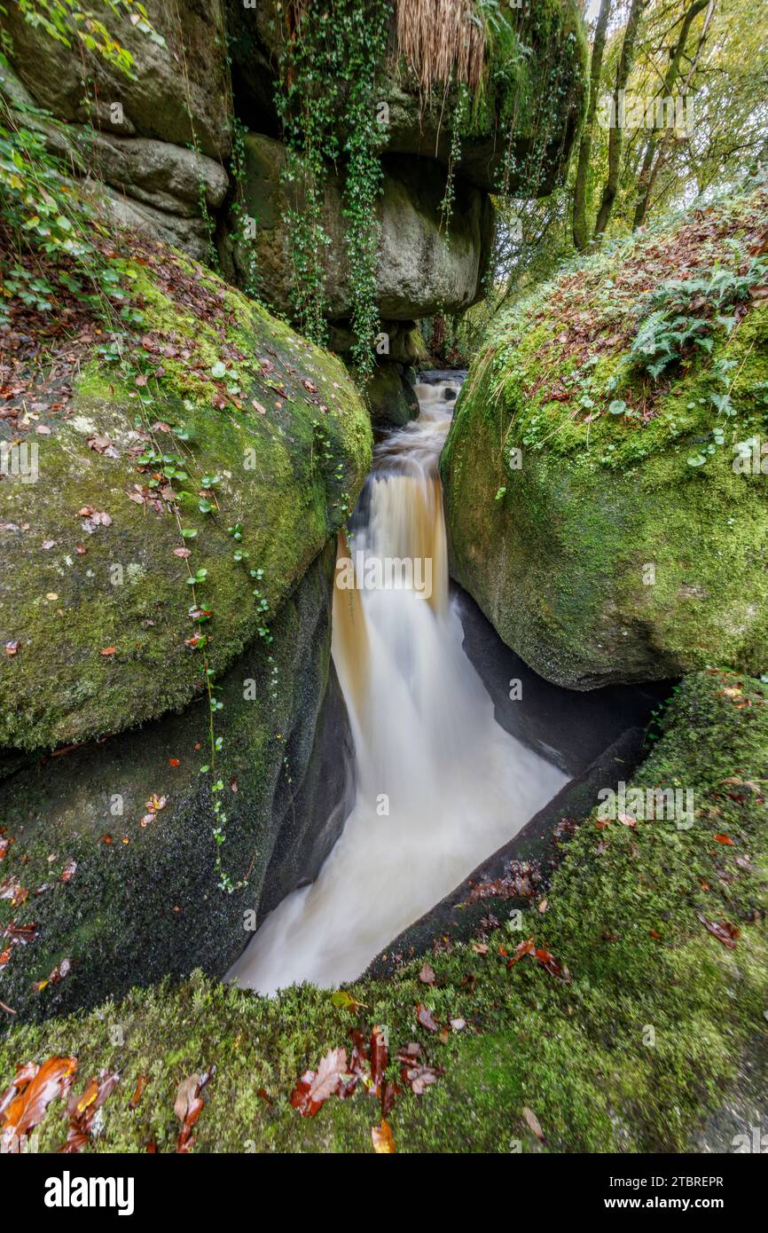 France, Bretagne, Huelgoat, Cascade le gouffre entre roches granitiques moussues dans la forêt d'automne de Huelgoat Banque D'Images