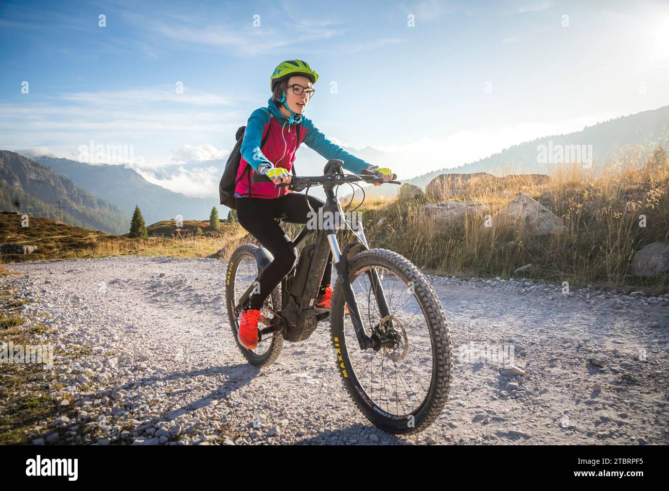 Italie, Vénétie, province de Belluno, activité de plein air, adolescente le long d'un chemin de terre en vélo électrique Banque D'Images