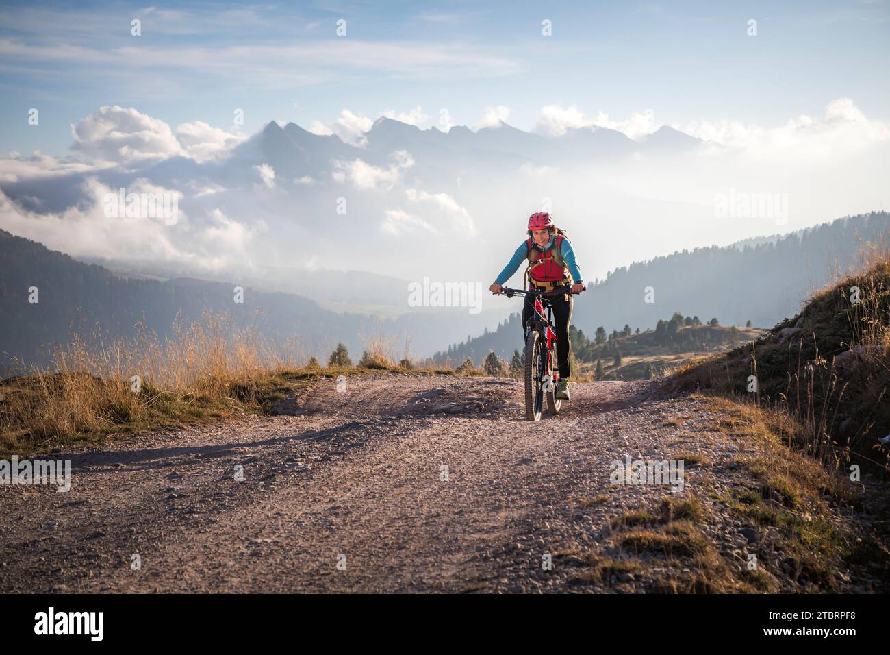 Italie, Vénétie, province de Belluno, activité de plein air, femme le long d'un chemin de terre à cheval sur un e-bike Banque D'Images
