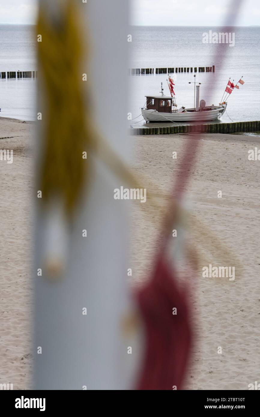 Allemagne, Mecklembourg-Poméranie occidentale, île d'Usedom, mer Baltique, bateau et groynes sur la plage, mât flou au premier plan Banque D'Images