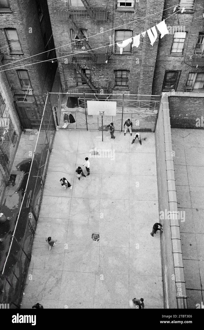 Vue à grand angle des enfants portoricains jouant au basket-ball dans la cour entourée de bâtiments, Lower East Side, près de 4th Avenue et Forsythe Street, New York City, New York, USA, Marion S. Trikosko, U.S. News & World Report Magazine Photography Collection, 4 novembre 1959 Banque D'Images