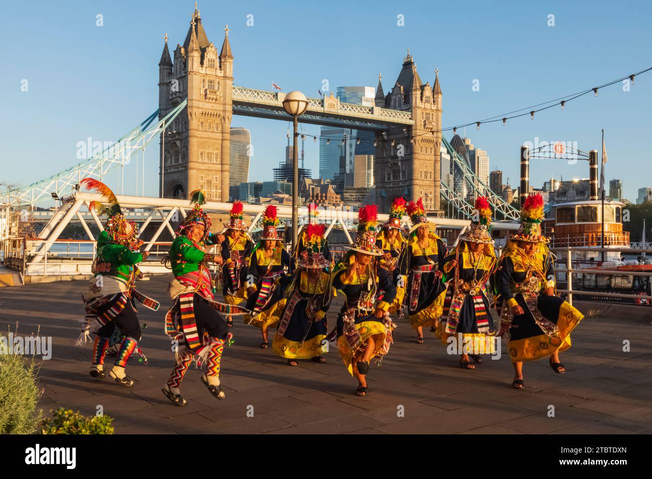 Angleterre, Londres, Groupe de danse bolivien coloré devant Tower Bridge Banque D'Images