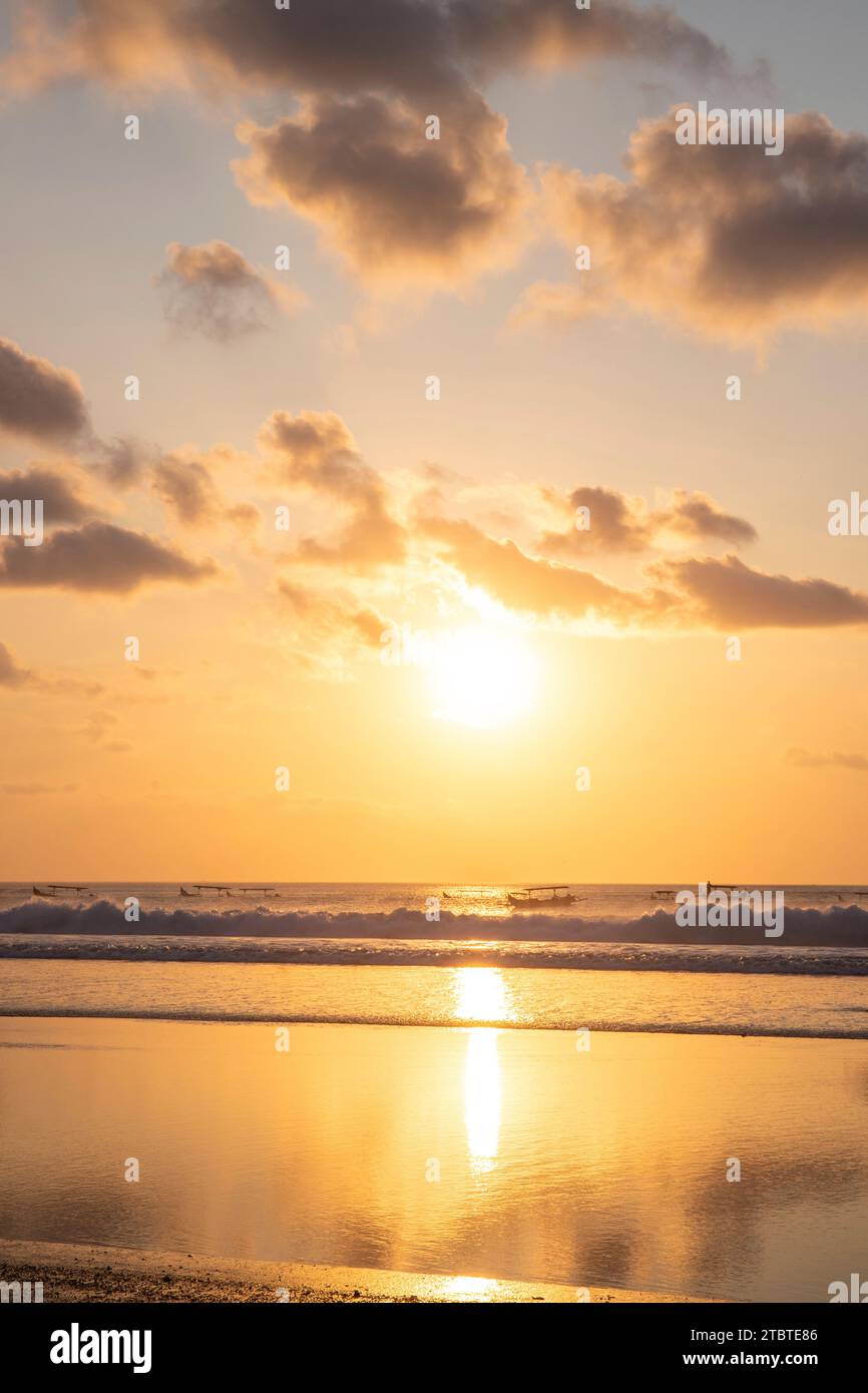 Coucher de soleil onirique sur la plage de rêve de Kuta, petites vagues dans la mer et le reflet du ciel dans les eaux peu profondes, Bali tropical, Indonésie Banque D'Images