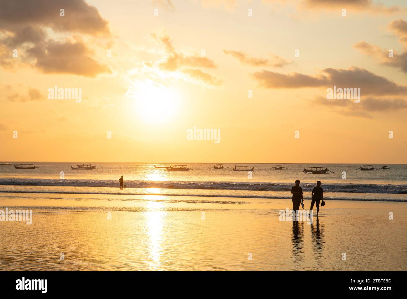 Coucher de soleil onirique sur la plage de rêve de Kuta, petites vagues dans la mer et le reflet du ciel dans les eaux peu profondes, Bali tropical, Indonésie Banque D'Images