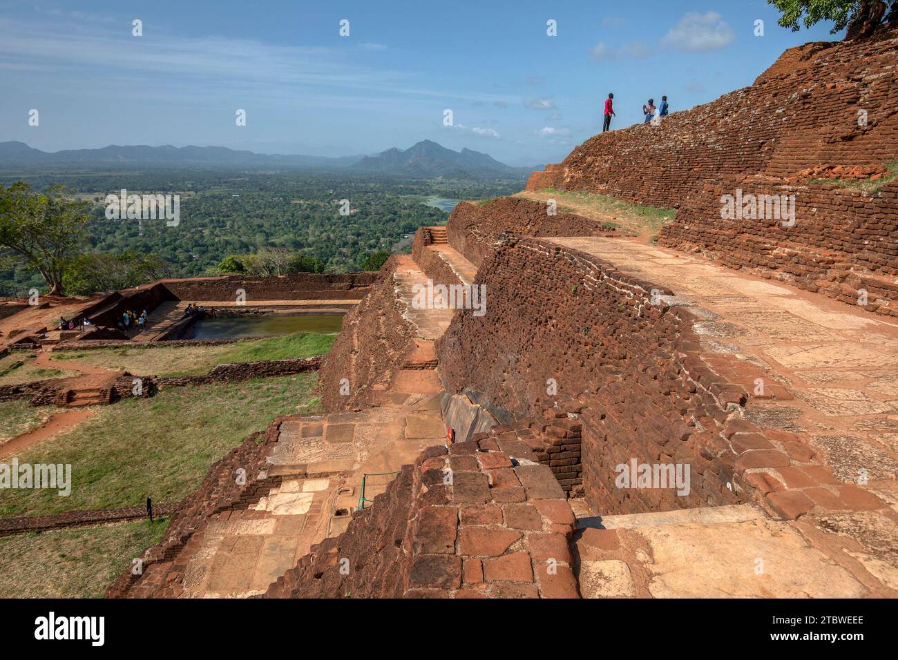 Les différents murs de briques rouges et escaliers regardant vers le réservoir d'eau artificiel au sommet de la forteresse rocheuse de Sigiriya au Sri Lanka. Banque D'Images