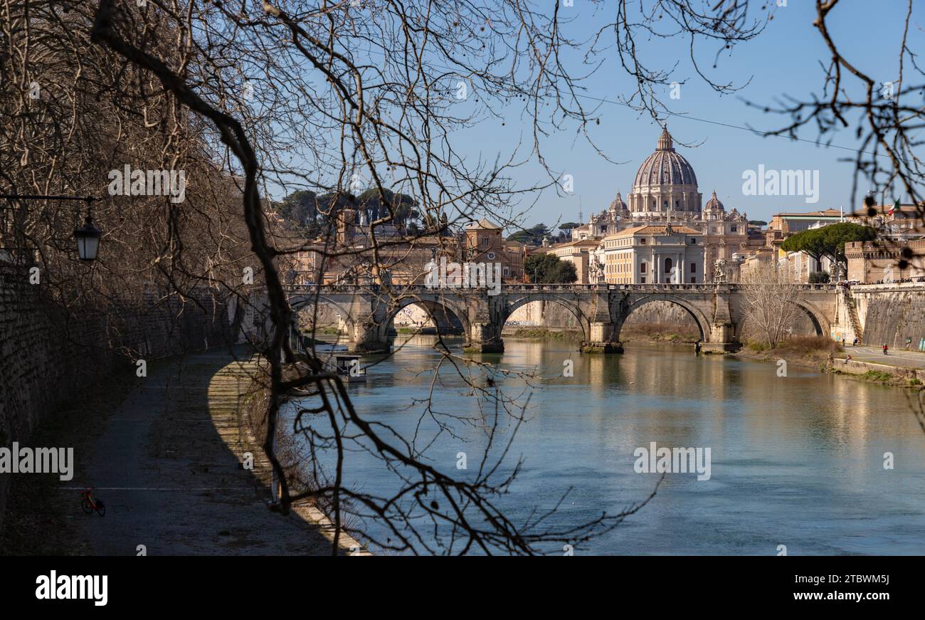 Une photo du St. Angelo Bridge, le St. Basilique Pierre et le Tibre vus à travers quelques branches voisines Banque D'Images
